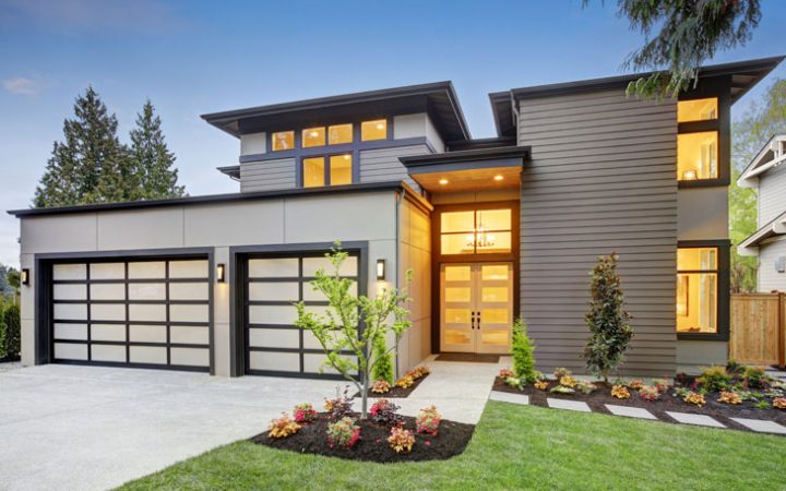 a modern custom home with a driveway, garage, and front yard landscaping